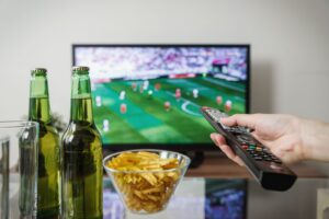 Nogometna utakmica na televizoru, pivo i daljinski upravljač